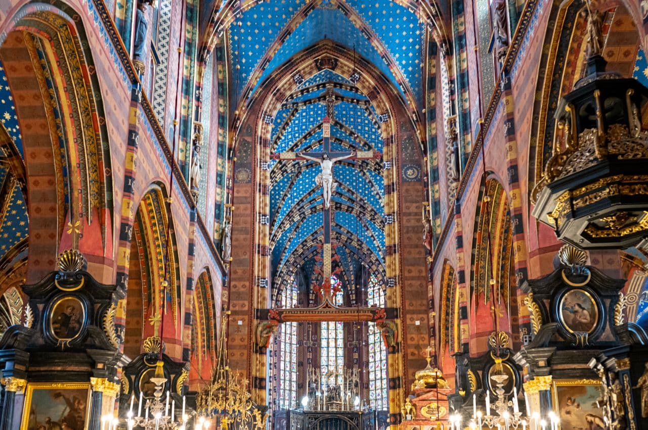 Ornate cathedral interior with colorful arches, intricate designs, and chandeliers.